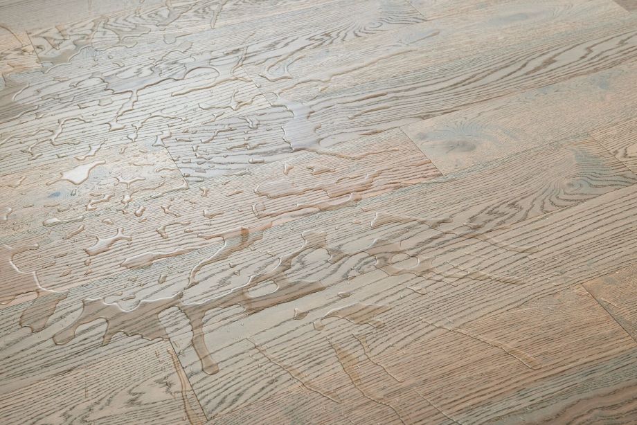 Close up of an engineered hardwood floor with water sitting on it; HydroBlok waterproof engineered wood flooring