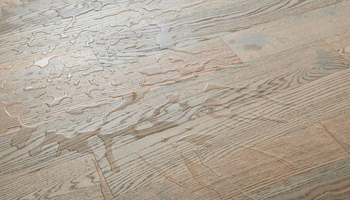 Closeup of a waterproof engineered hardwood floor with water on its surface