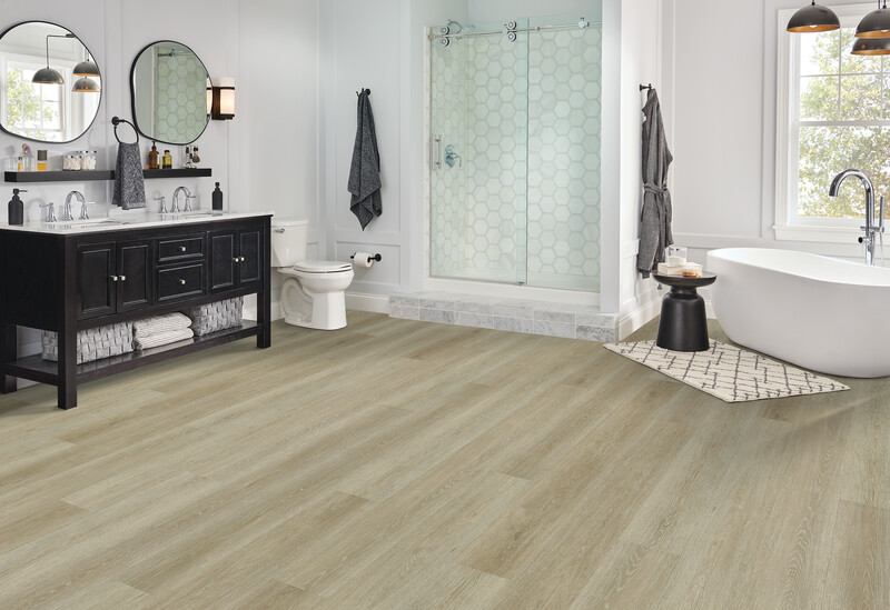 Rigid core vinyl flooring in a bathroom with a walk in shower and vanity