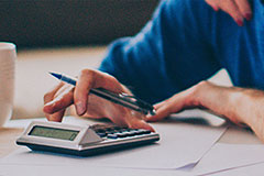 man typing in numbers on calculator