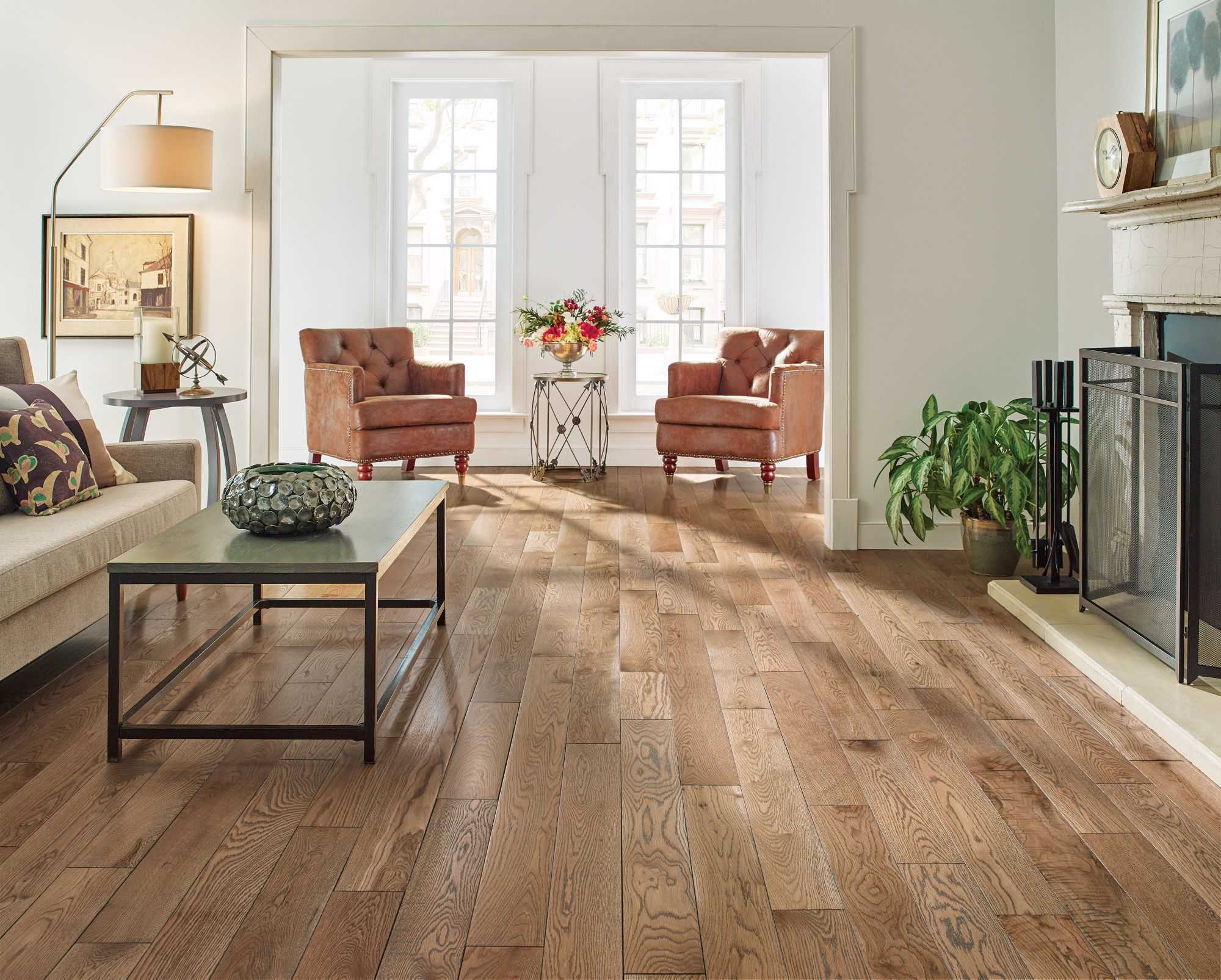 living room with a fireplace that opens to a seating area featuring hardwood flooring from Hartco